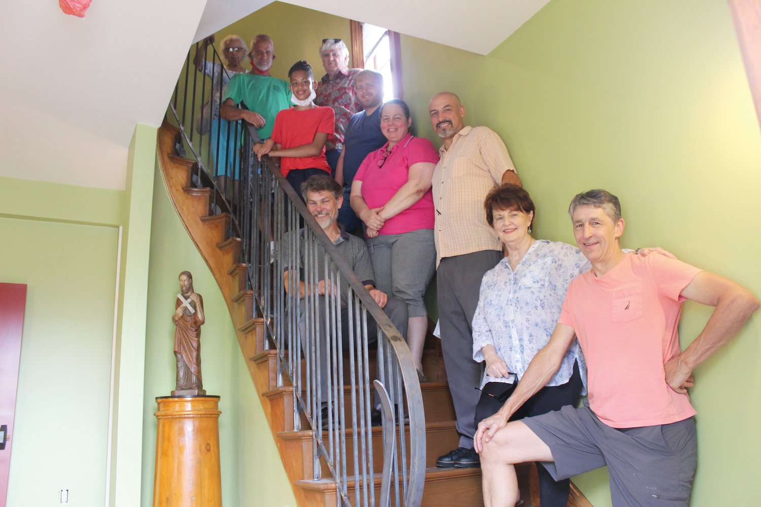 Project supporters and members of the Smith Hill community gather on the central stairs of the new St. Andrew House at the residence’s Open House on July 11.  Dr. Boyd Taylor Coolman stands third from right, with Dr. Jeremy Wilkins seated along the railing.